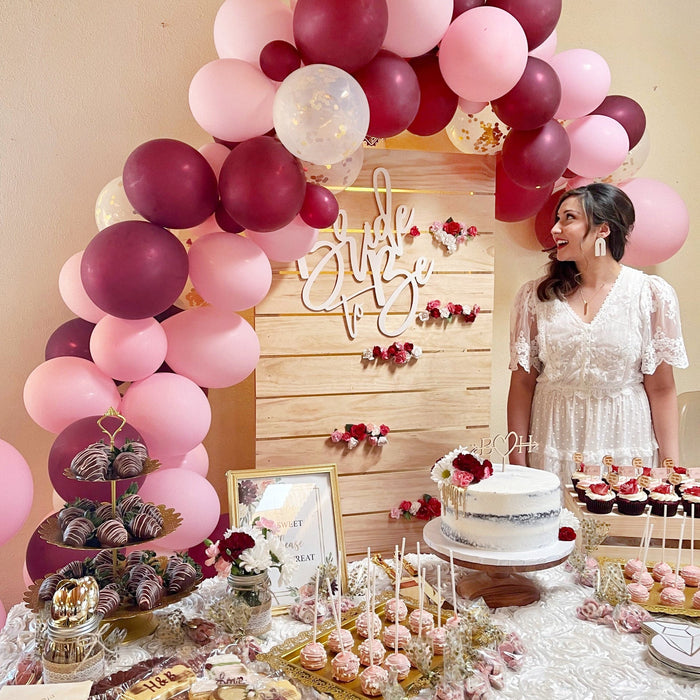 Pink and burgundy balloon arch cluster with helium balloons