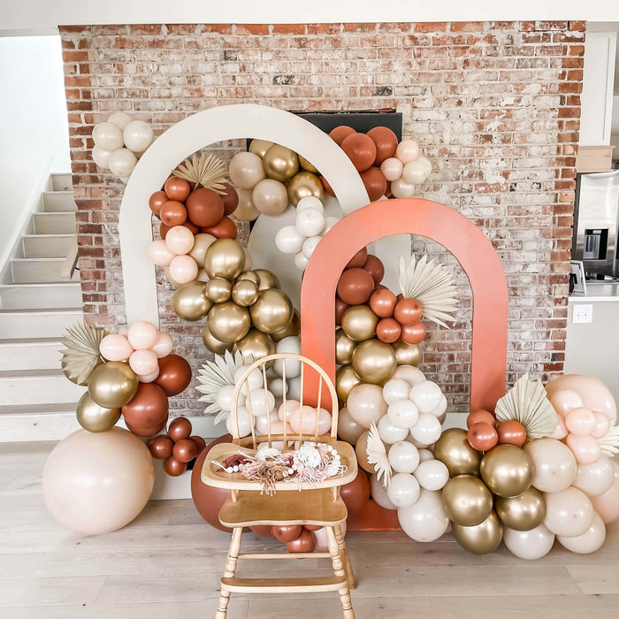 Balloon arch display with cream, gold, and peach latex balloons