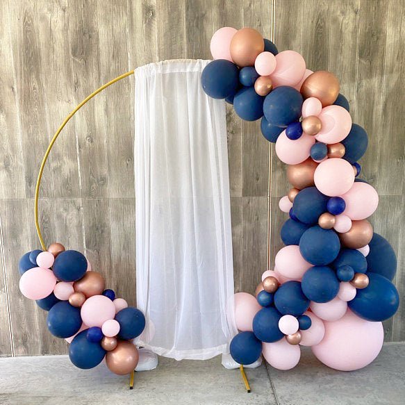 Navy blue and blush pink latex balloon cluster with gold accents and ribbon ties