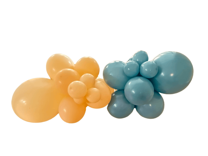 Peach and teal latex balloon cluster with five large balloons and small accents.