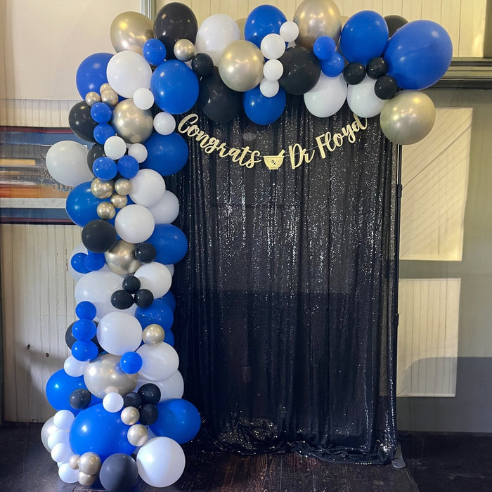 Balloon garland arch with royal blue, white, black, and metallic silver accents