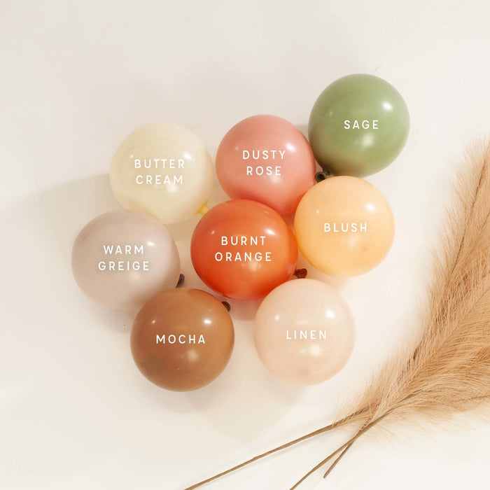 Assorted latex balloon colors, including sage green balloons in a pastel palette
