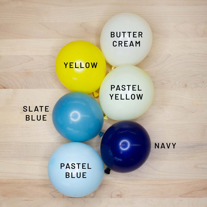 Latex balloon cluster with yellow, cream, light blue, and navy blue balloons