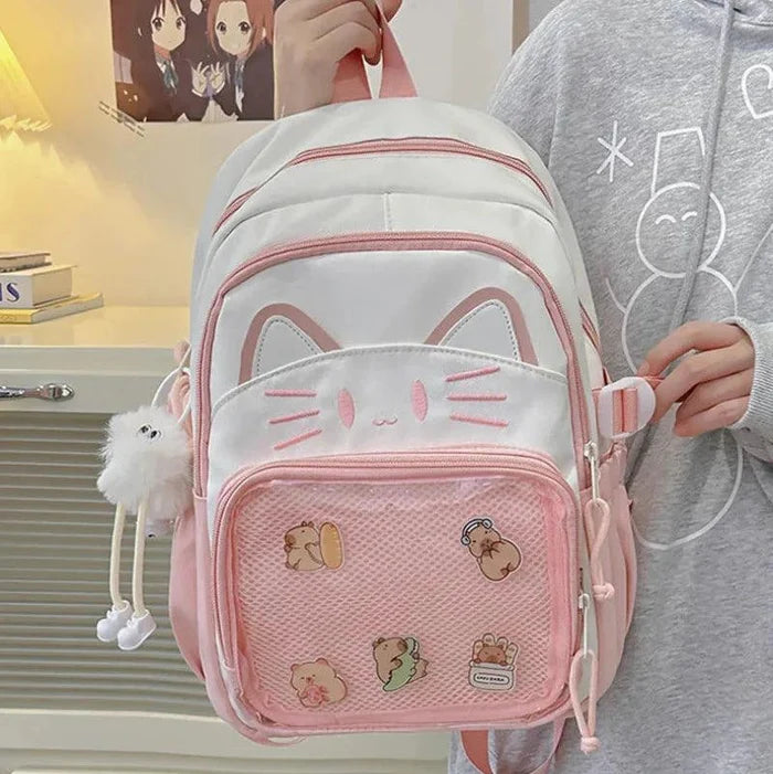 Pink ita-style school backpack angled view with cat-face patch and front mesh pocket