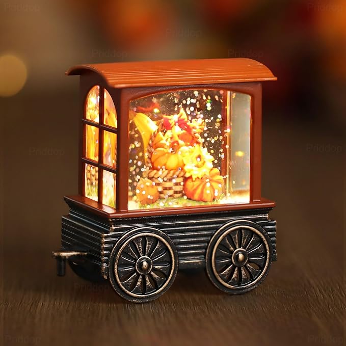 Side view of orange cabin steam train snow globe with black wheels and sparkling light effect