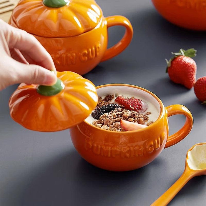 Pumpkin-shaped ceramic mug with lid, orange glaze, green stem, loop handle