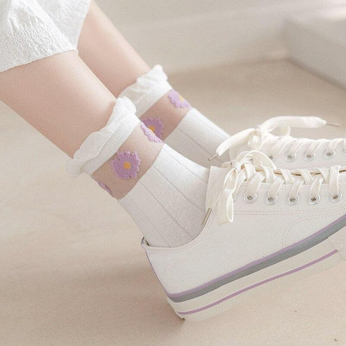 White ankle socks with lavender floral accents and ruffled cuff, worn