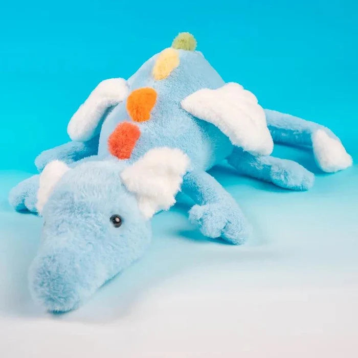Light blue plush dragon with white wings and multicolor felt spots, lying down