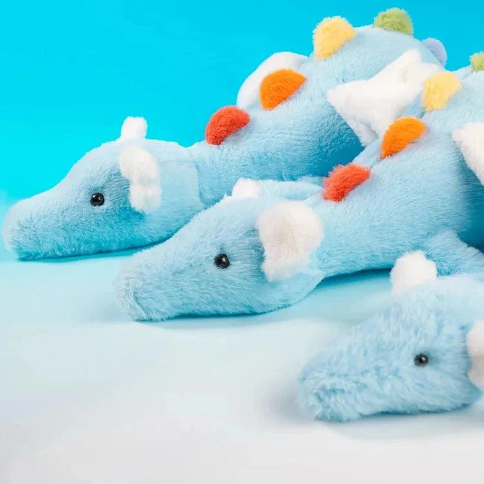 Three light blue plush dragons with white wings and multicolor pom-pom spots