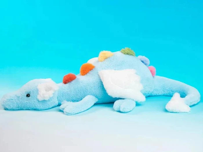 Light blue plush dragon with white belly and colorful pom-pom back, lying down