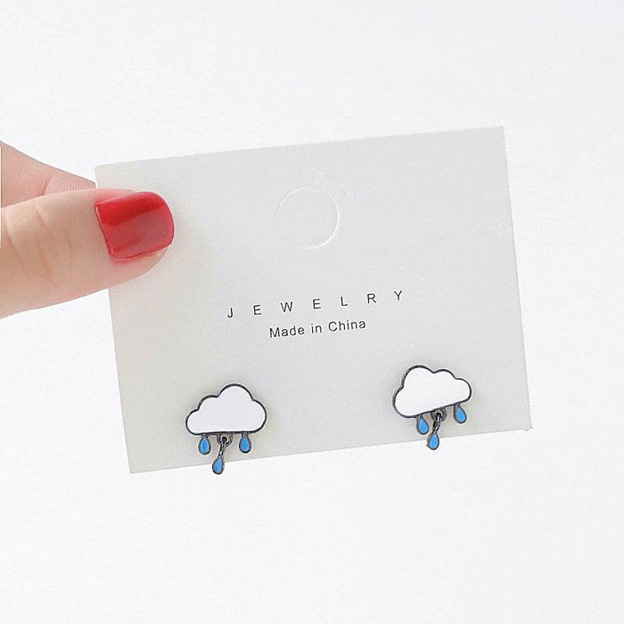 Cloud stud earrings with blue raindrop dangles, black outline, on jewelry card