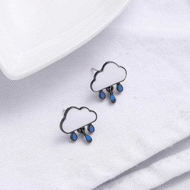 Cloud rain earrings with blue drops and black outlines on white fabric