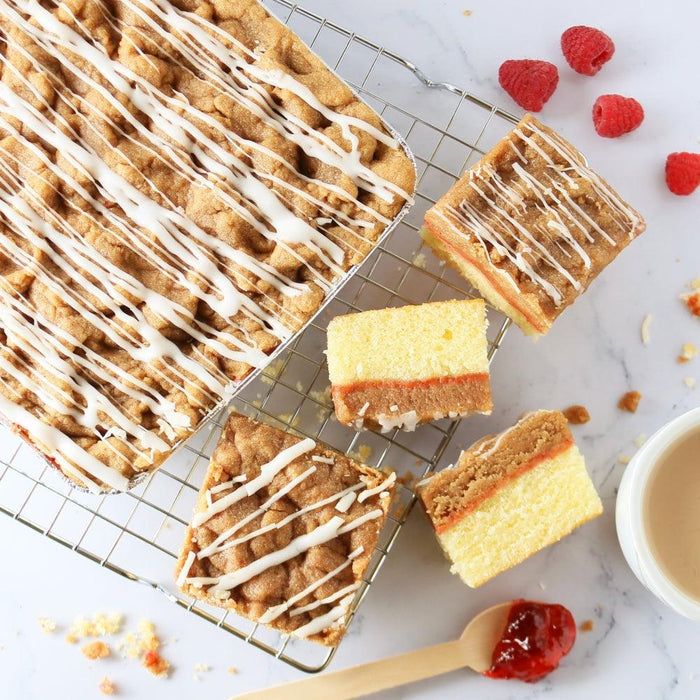 Frosted cake slices on wire racks with berries and crumbs