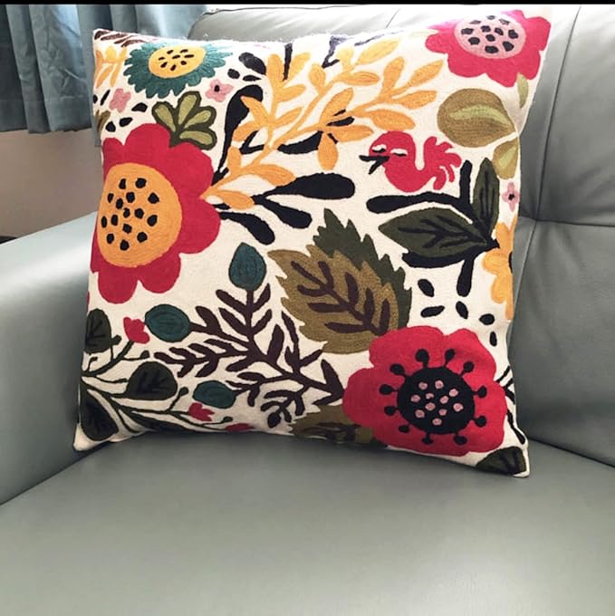 Multicolor floral bird cushion cover with red blooms on light fabric.