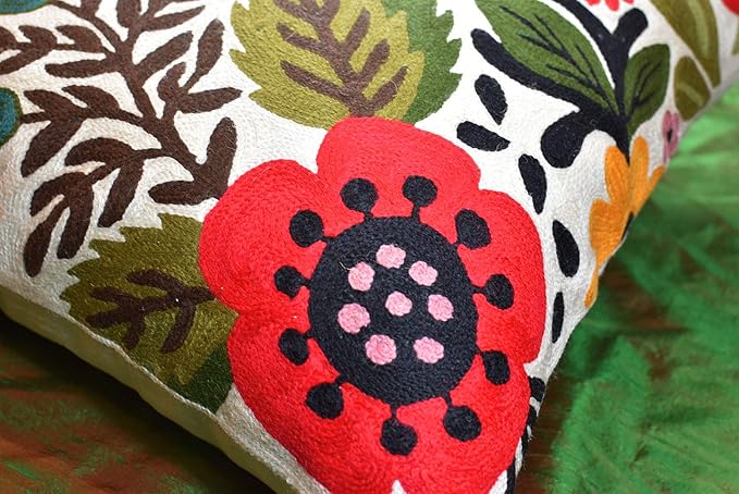 Close-up of embroidered floral bird pillow cover with a red flower and green leaves.