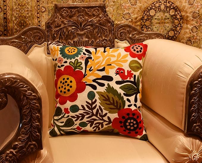 Floral bird pillow cover on a decorative leather chair with ornate detailing.
