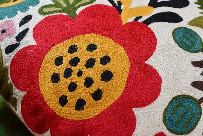 Close-up of a large red embroidered flower with a yellow center on the pillow cover.