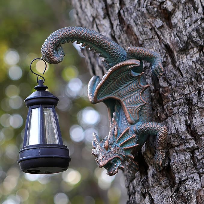 Dragon tree hugging wall decor with black solar lantern hanging from a dark bronze form