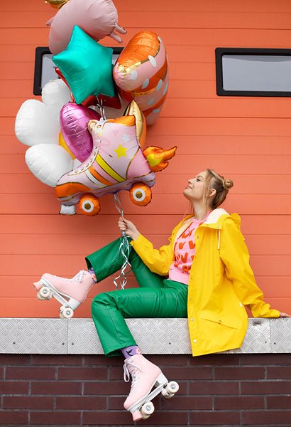 Roller skate-shaped balloon held by a person, orange wheels and gold striped design