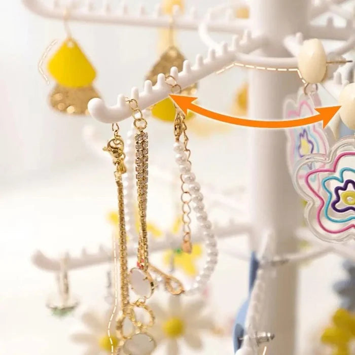 Hanging earrings on white hook arms of earring display stand, close-up