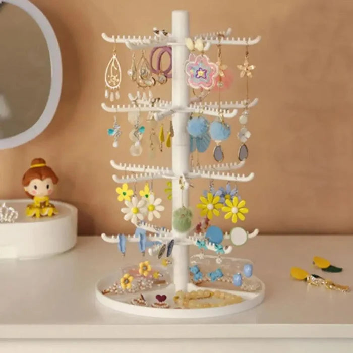 White tiered earring display stand with star and flower earrings hanging