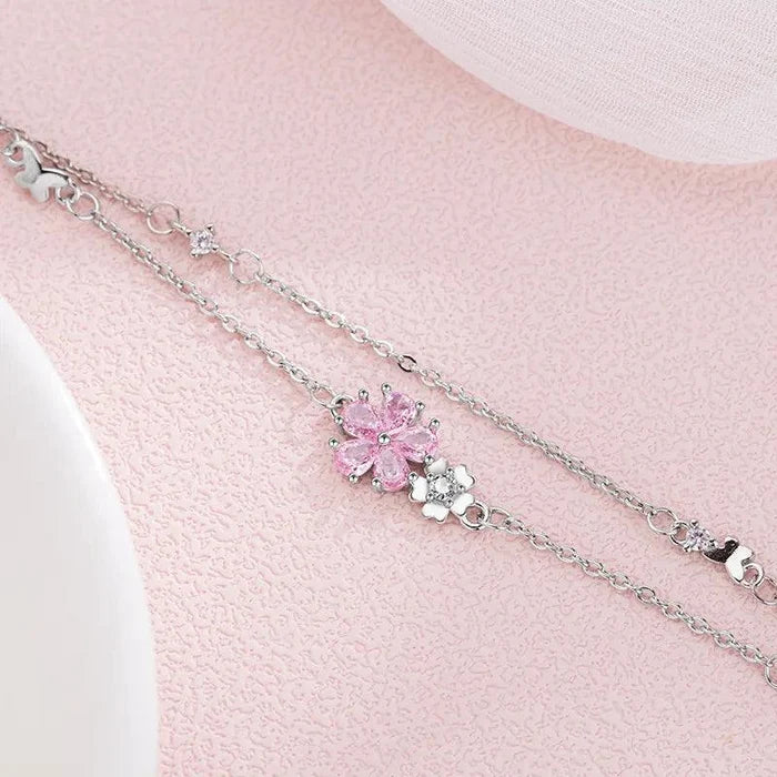 Silver charm bracelet with pink cherry blossom flower and small heart accents