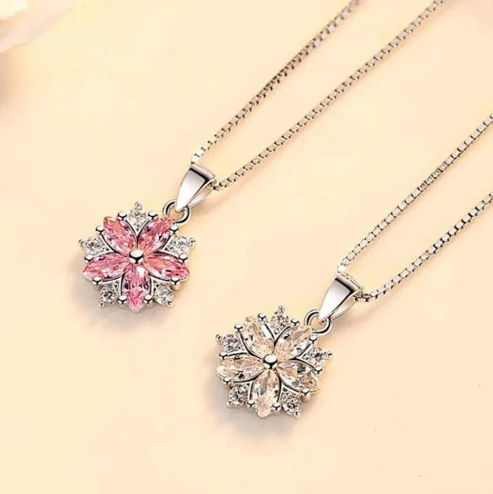 Silver-toned necklace set with pink cherry blossom pendants, chain and rings visible