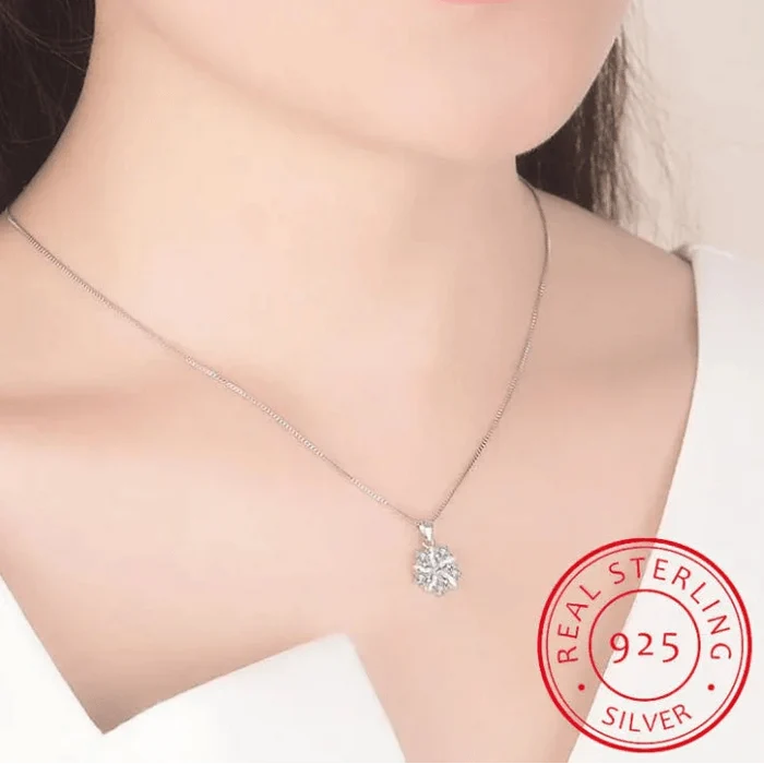 Silver-toned chain necklace with small pink flower pendant resting at the collarbone