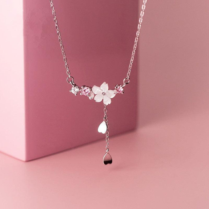 Silver tone flower charm pendant necklace with hanging teardrop and small beads