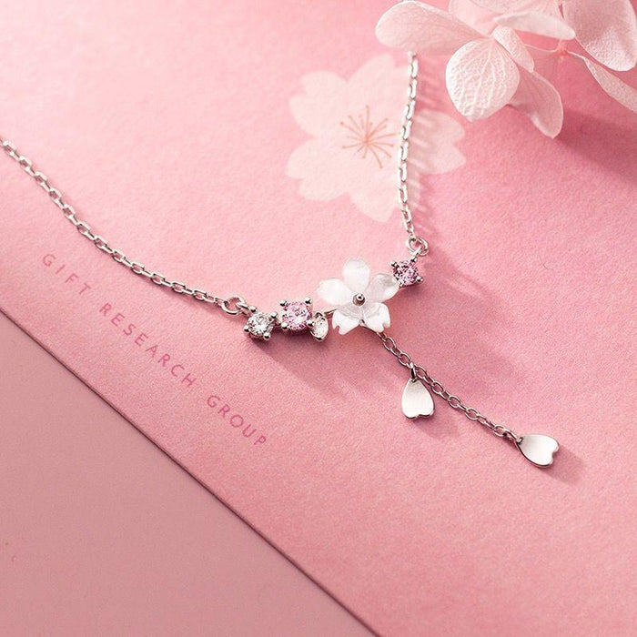 Silver tone charm pendant necklace with cherry blossom and dangling teardrop charm