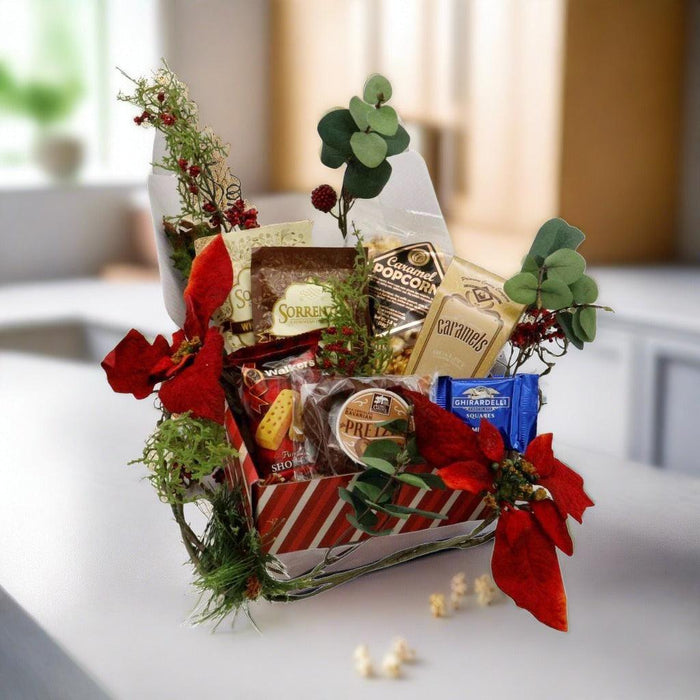 Wrapped gift box with assorted chocolates and candy, decorated with green eucalyptus stems