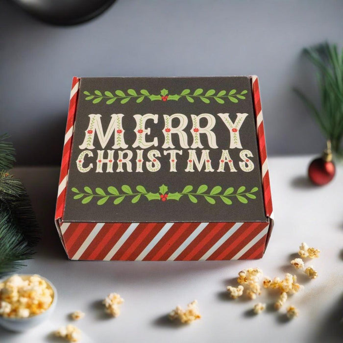 Festive gift box with 'MERRY CHRISTMAS' on the lid, red and green striped sides