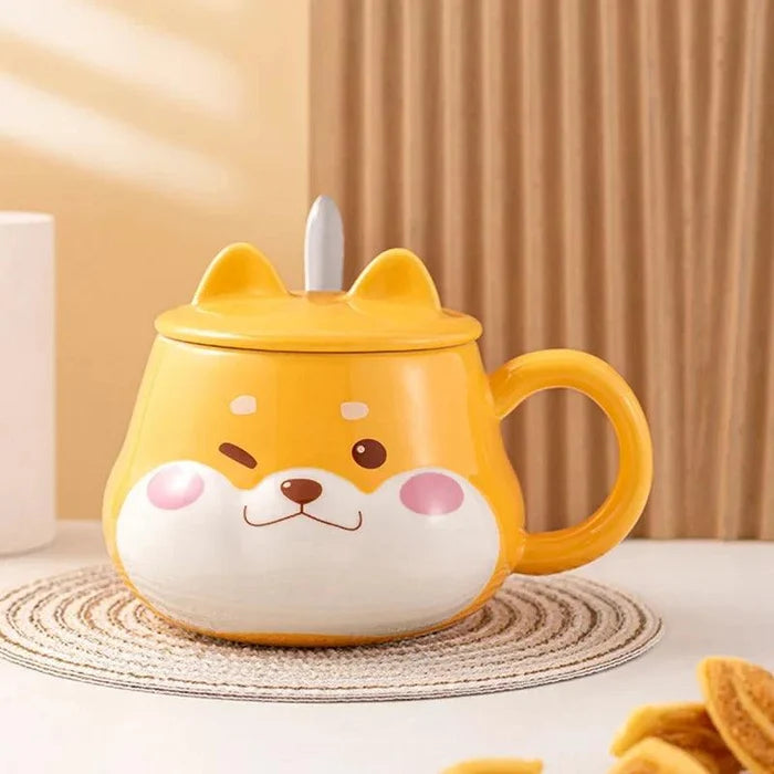 Yellow dog-face mug with lid and side handle, angled view on a striped coaster