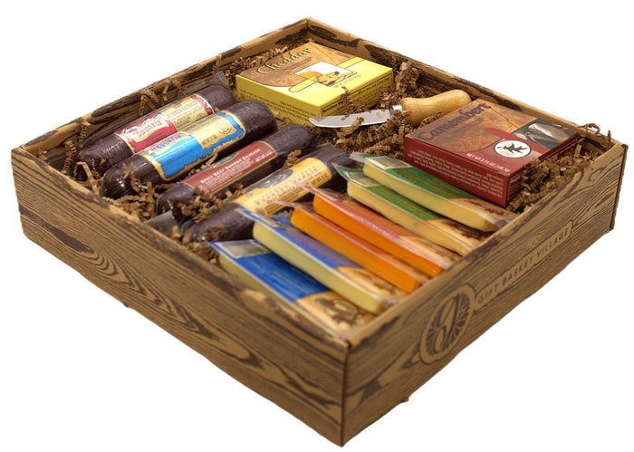 Open wooden gift box with sausages, cheese packs, crackers, and a wooden-handled spreader