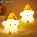 Silicone star LED night light, glowing white body with yellow cap and handle