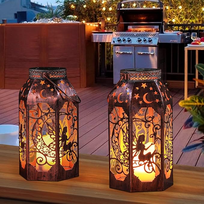 Two bronze solar LED lanterns with intricate cutout silhouettes, warm glowing light, outdoor deck