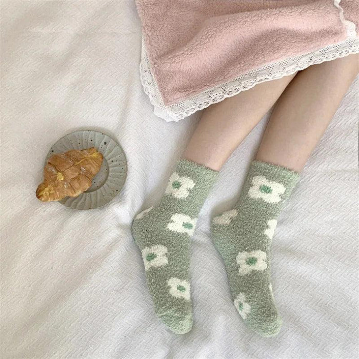 Soft plush sleeping socks in sage green with white cloud-like icons and green accents