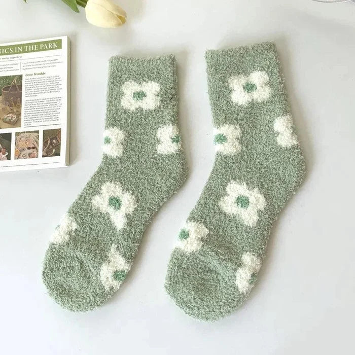 Plush sleeping socks in green with white flower prints and scattered small motifs