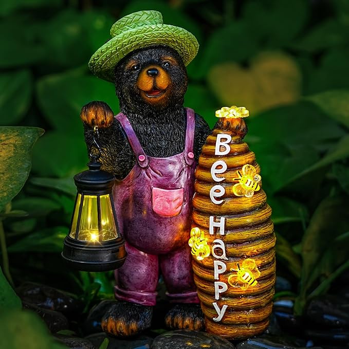 Solar bear garden statue with green hat, purple overalls, lantern, and beehive stack.