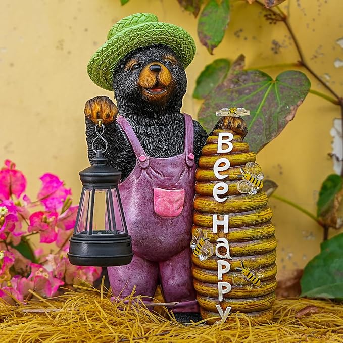 Solar bear statue with green cap, purple overalls, lantern in one hand, beehive stack.