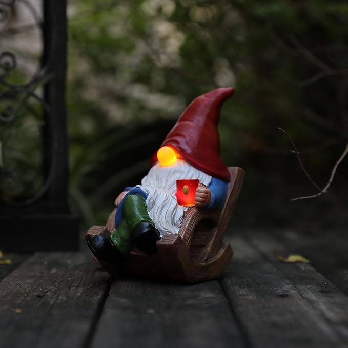 Solar-powered garden gnome figurine in a wooden sled holding a lantern, warm glow