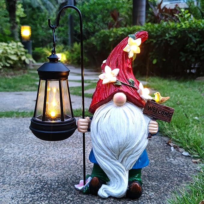 Solar garden gnome statue holding a black lantern with warm glowing light, red flower hat