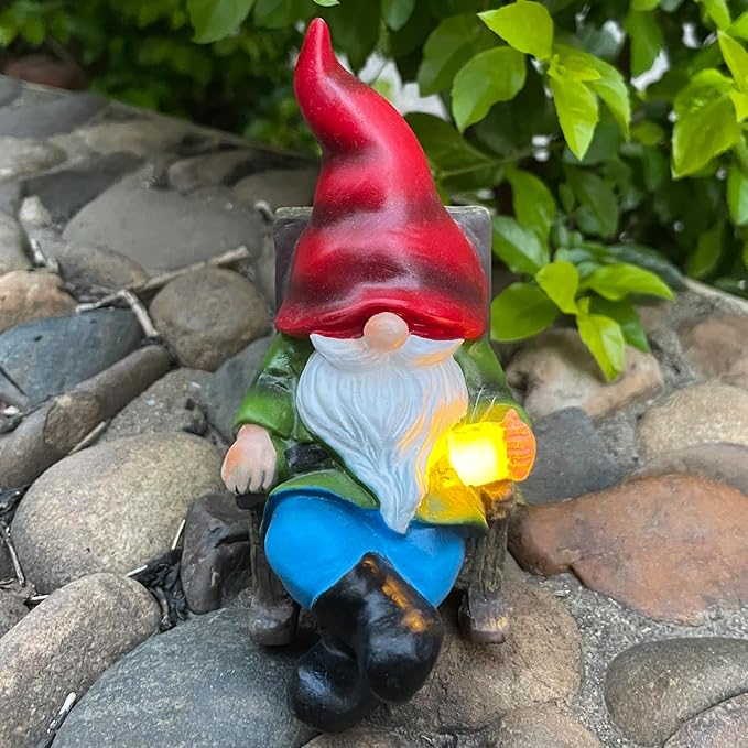 Solar gnome figurine with red hat, white beard, blue pants, glowing lantern light