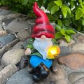 Solar gnome figurine with red hat, white beard, blue pants, glowing lantern light
