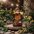 Solar highland cow garden statue with perched gnome and warm solar fairy lights