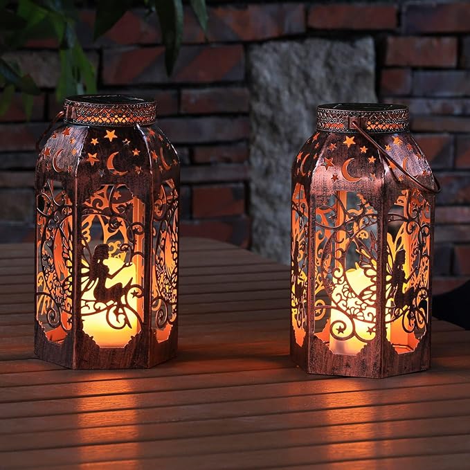 Two bronze metal lanterns with fairy and moon cutout panels, warm glowing light