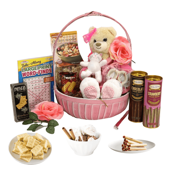 Pink gift basket with plush bear, chocolate and strawberry cans, and packaged snacks