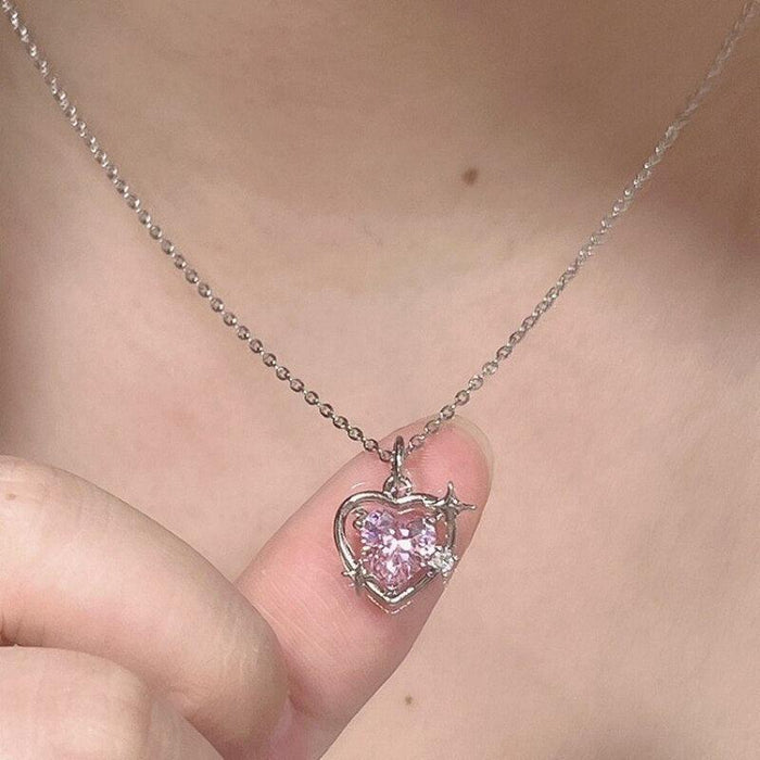 Heart crystal pendant necklace with pink stone and silver setting, shown on neckline