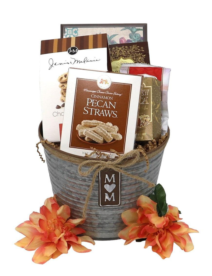 Mom gift tin basket with "M M" tag, orange flowers, and assorted gift packages