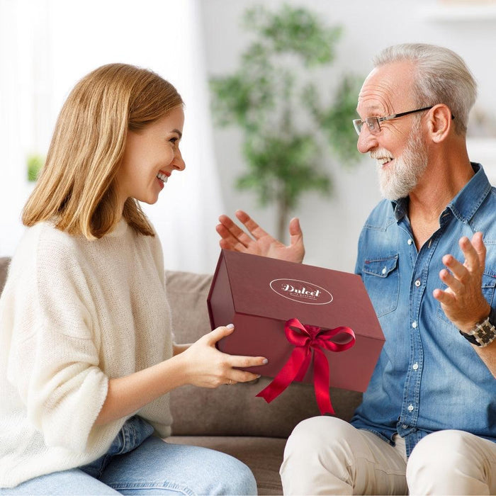 Gift box held by two people, with a red ribbon bow